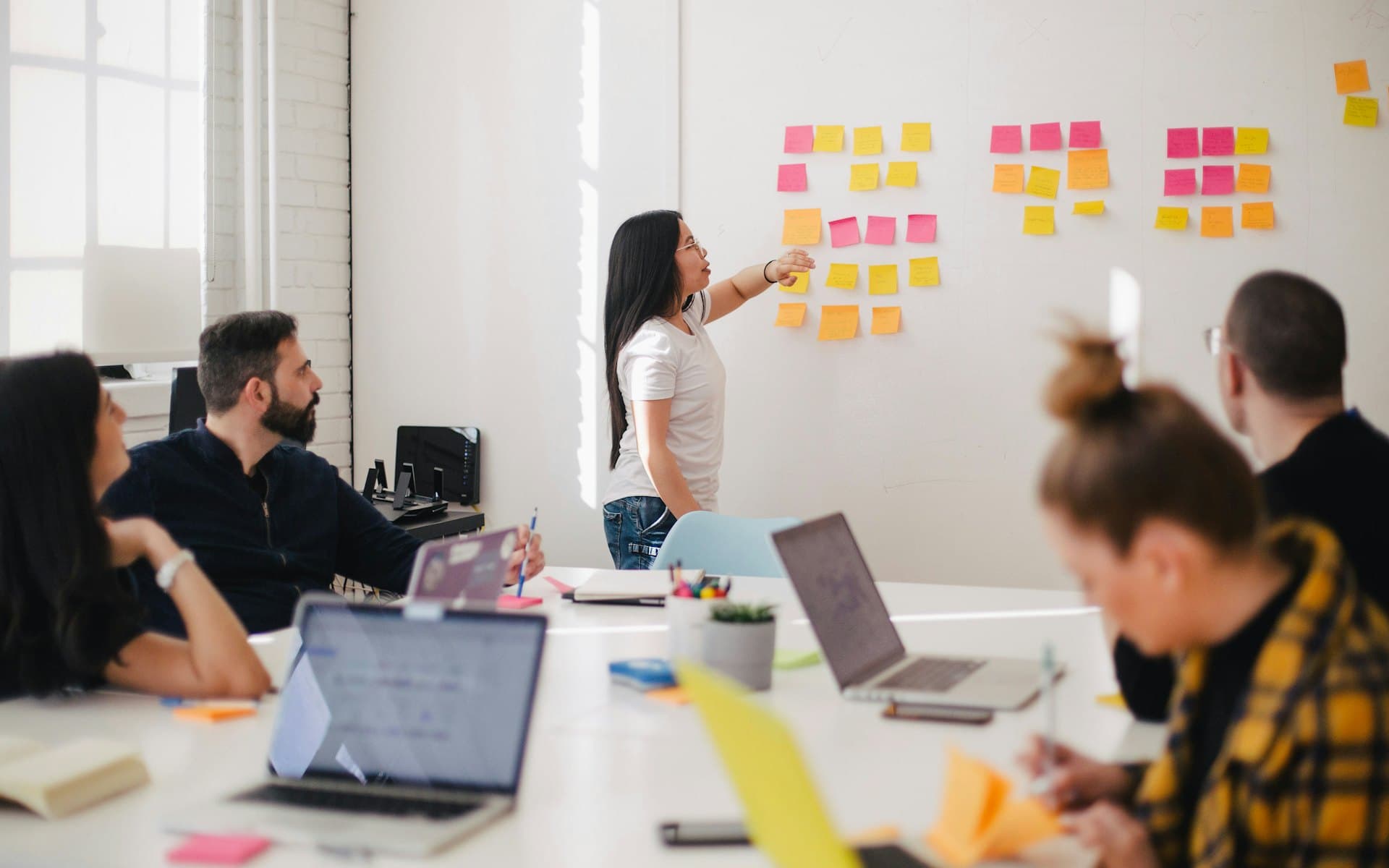 A team running a discovery workshop with sticky notes on a wall