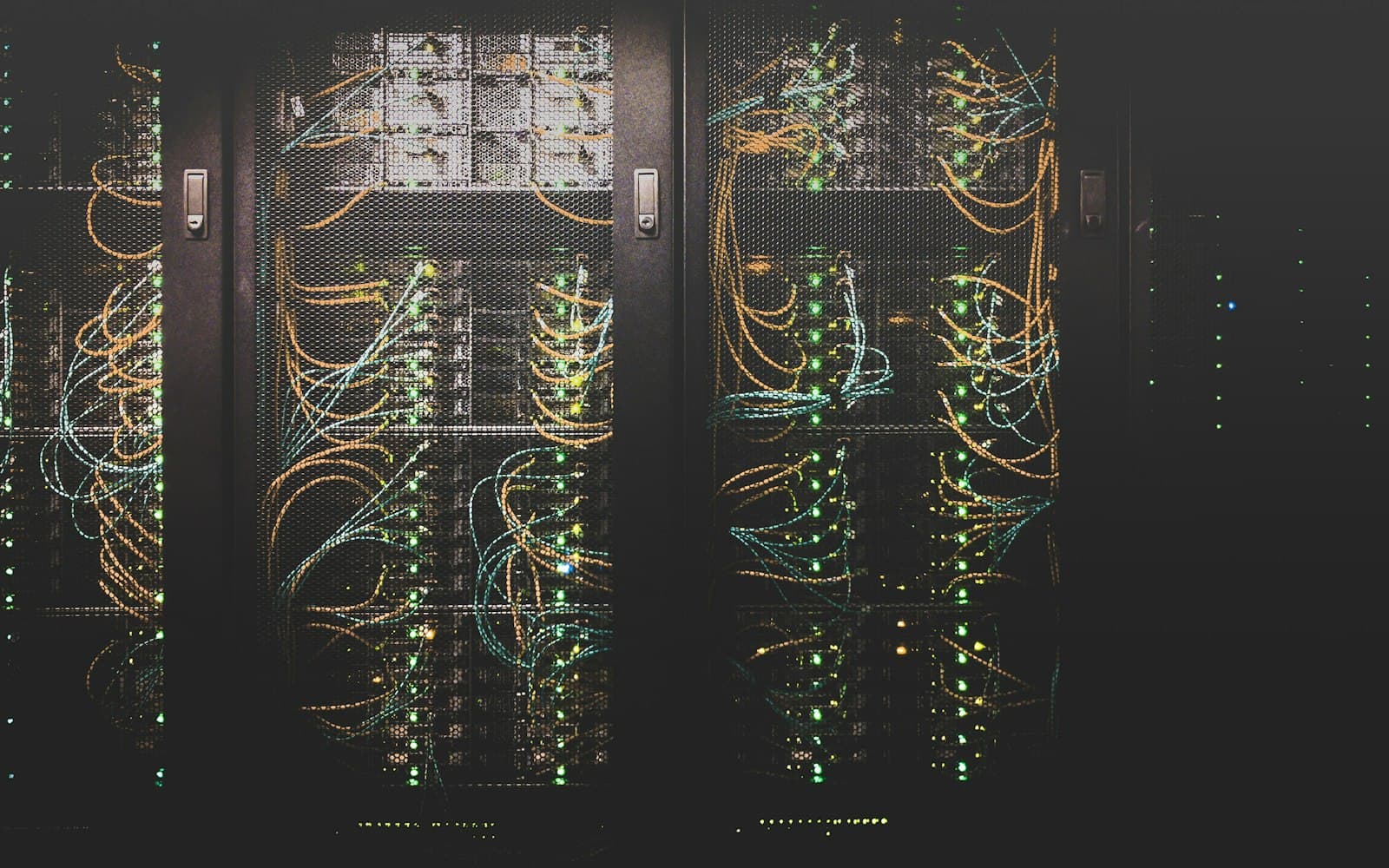 Server racks threaded with orange and blue network cabling